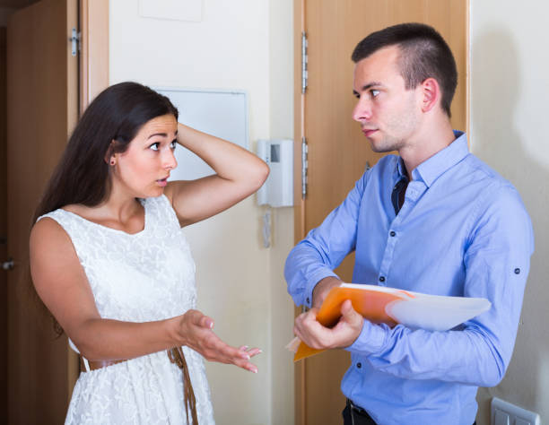 Young woman and man having argue with documents at doorway