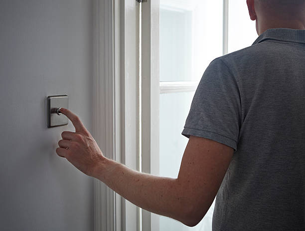 Man turning off light switch