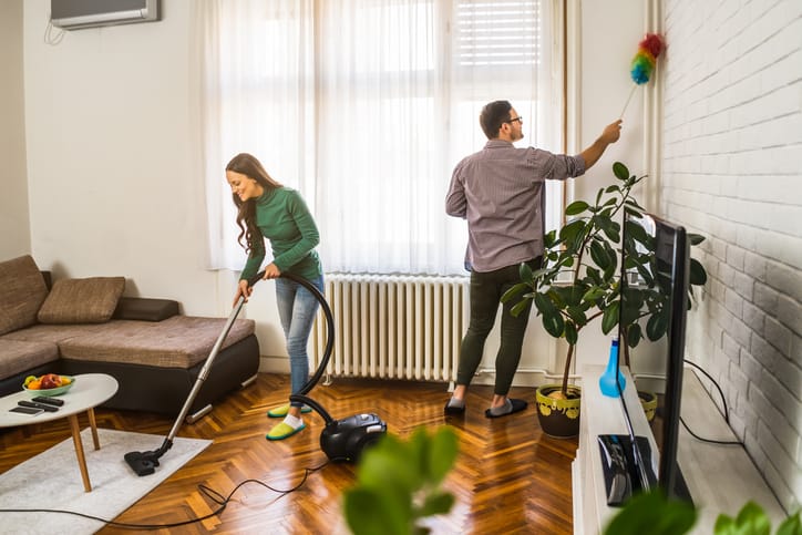 Young happy couple is cleaning their apartment.