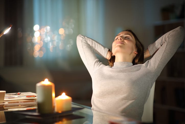 Relaxed woman resting in the night with candles